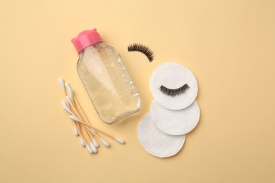 Flat lay composition with makeup remover and false eyelashes on yellow background