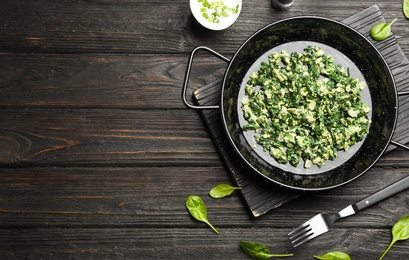 Photo of Flat lay composition with tasty spinach and space for text on black wooden table. Healthy food