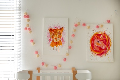 Photo of Cute pictures on white wall in baby room interior