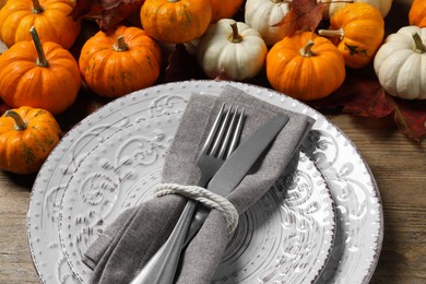 Happy Thanksgiving day. Beautiful table setting, autumn leaves and pumpkins on wooden background, closeup