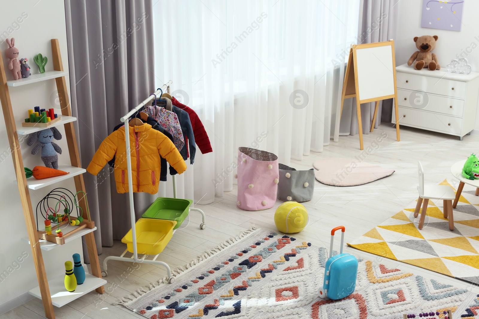 Photo of Child`s playroom with different toys and modern furniture. Stylish kindergarten interior