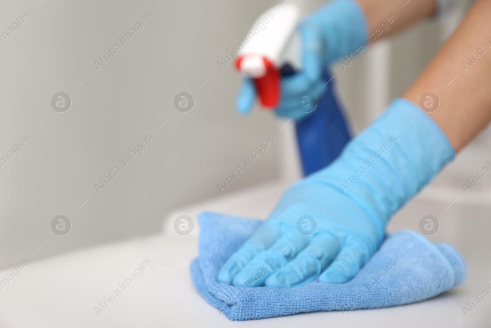 Photo of Woman cleaning toilet bowl with rag and detergent in 
store, closeup