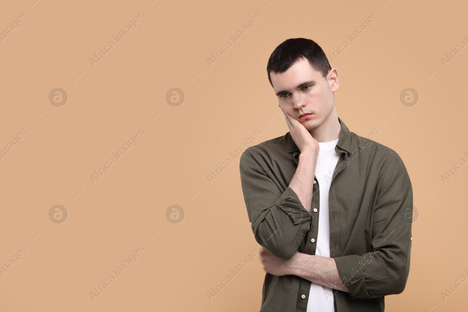 Photo of Portrait of sad man on beige background, space for text