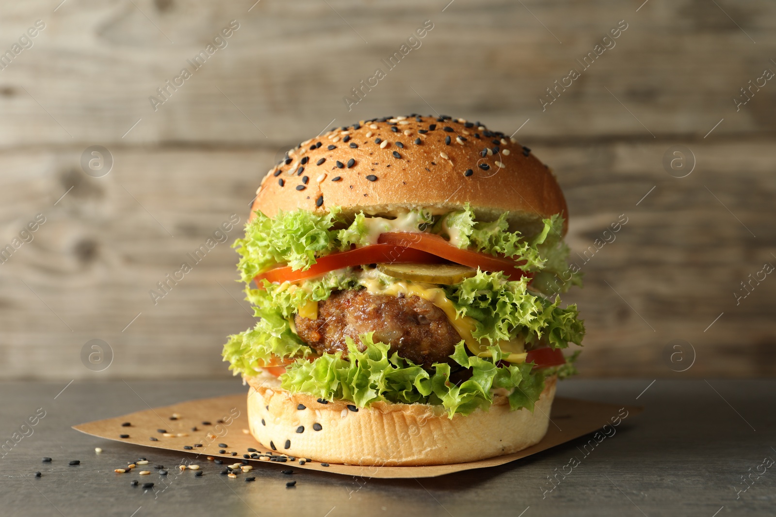 Burger with delicious patty on gray table Photo of Burger with delicious patty on gray table