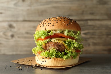 Photo of Burger with delicious patty on gray table