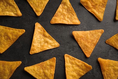 Flat lay composition of tasty tortilla chips (nachos) on grey table