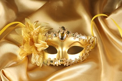 Beautifully decorated face mask on golden fabric. Theatrical performance