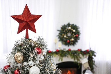 Beautiful Christmas tree with star topper in decorated room