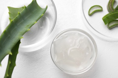 Aloe vera gel and slices of plant on white background, flat lay