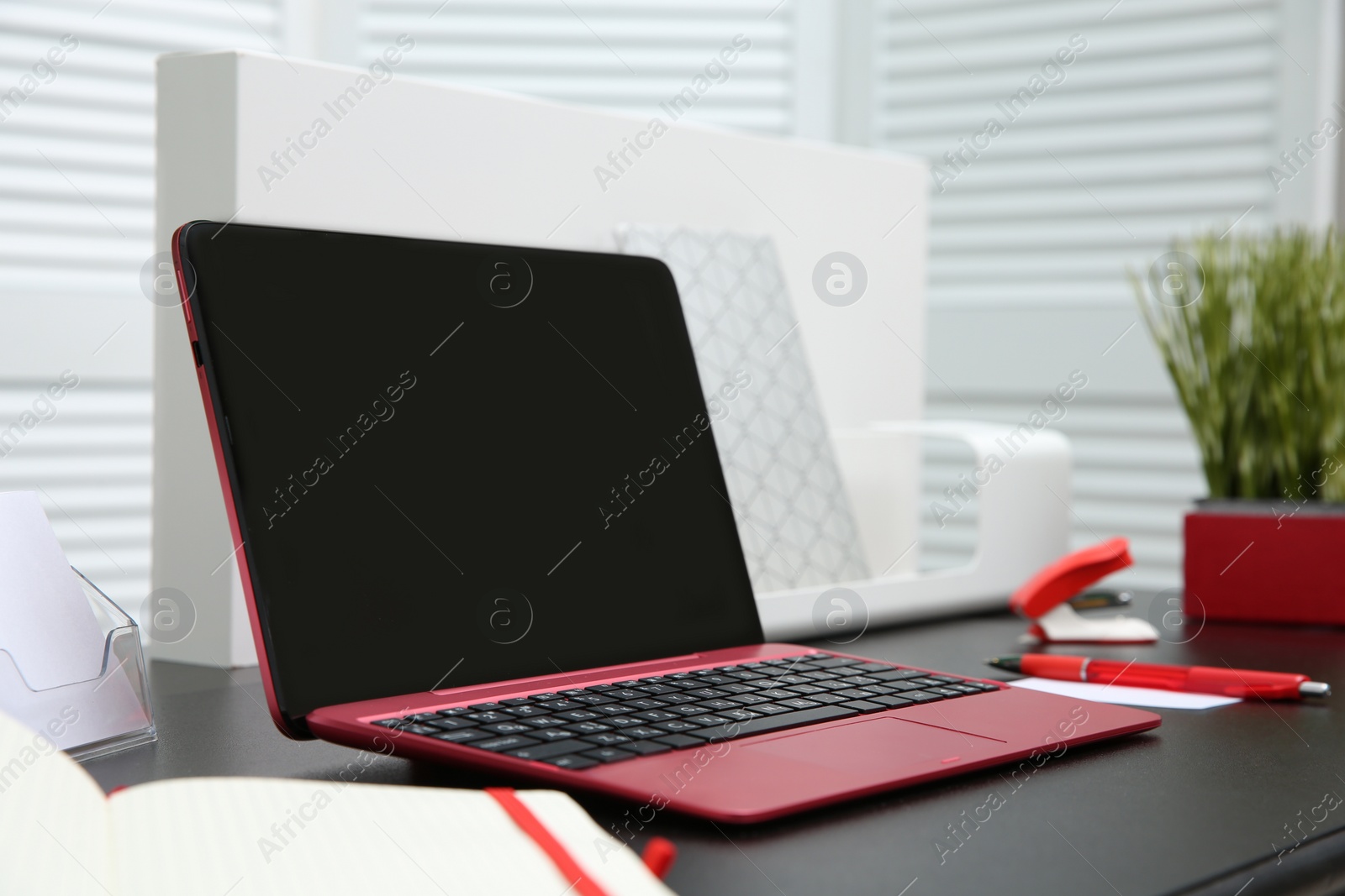 Photo of Stylish workplace with modern laptop on desk