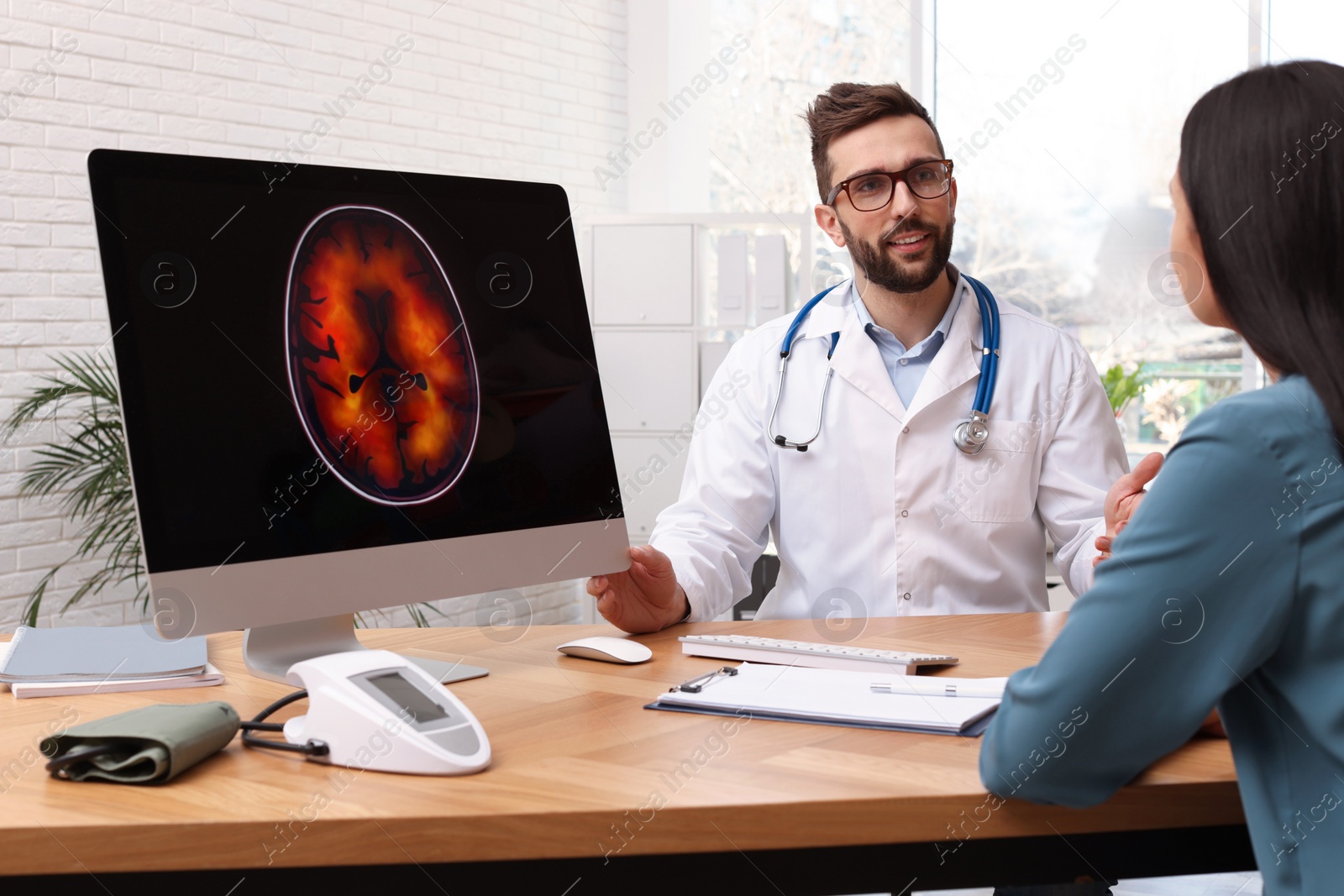 Photo of Neurologist consulting young patient at table in clinic