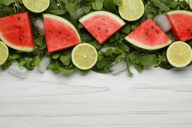 Photo of Tasty sliced watermelon, limes, mint and ice on white wooden table, flat lay. Space for text