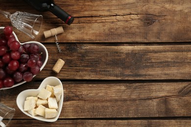 Photo of Tasty red wine and snacks on wooden table, flat lay. Space for text