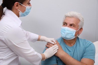 Photo of Doctor taking care of senior man with protective mask at nursing home