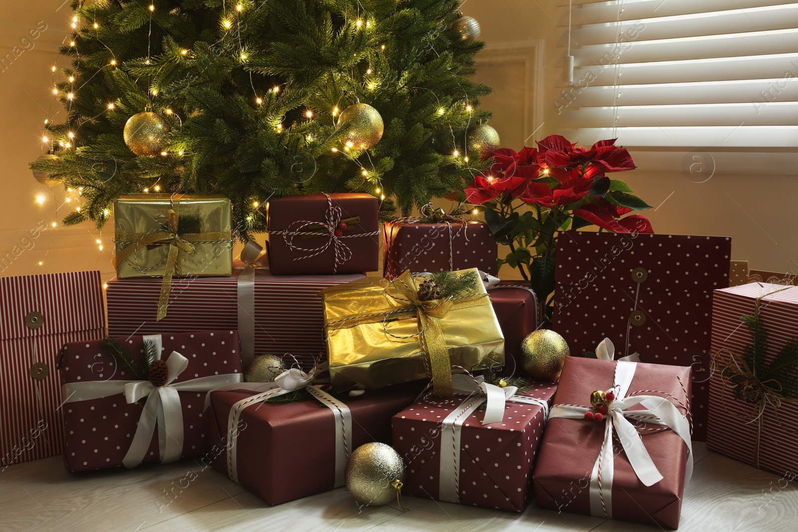 Photo of Many different gifts under Christmas tree indoors