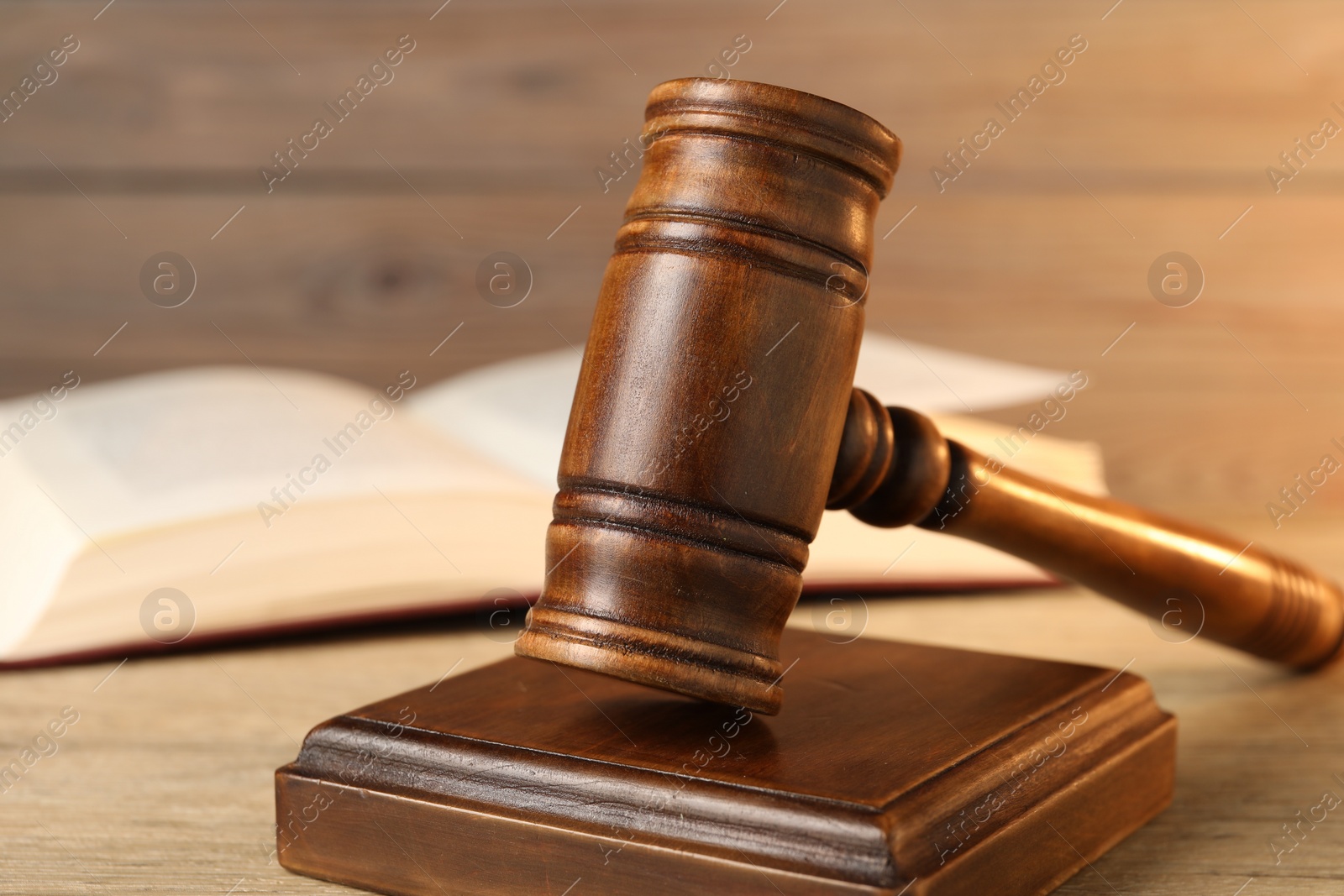 Photo of Wooden gavel and sound block on table, closeup