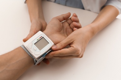 Photo of Doctor checking patient's blood pressure in hospital, closeup. Cardiology concept