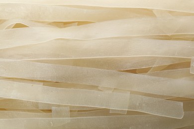 Raw rice noodles as background, closeup view