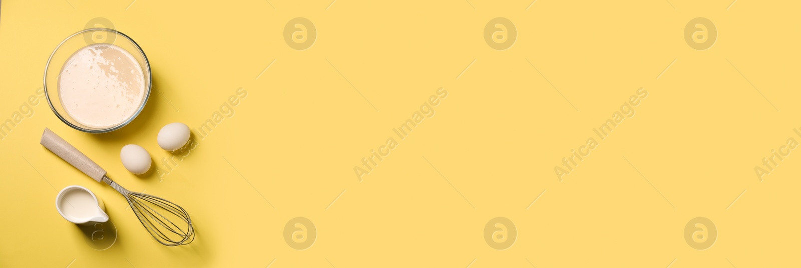 Image of Metal whisk, dough, eggs and milk on yellow background, flat lay. Banner design with space for text