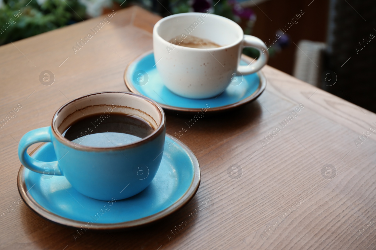 Photo of Cups of fresh aromatic coffee on wooden table