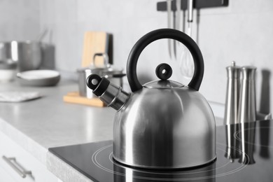 Photo of Stainless steel kettle on electric stove in kitchen