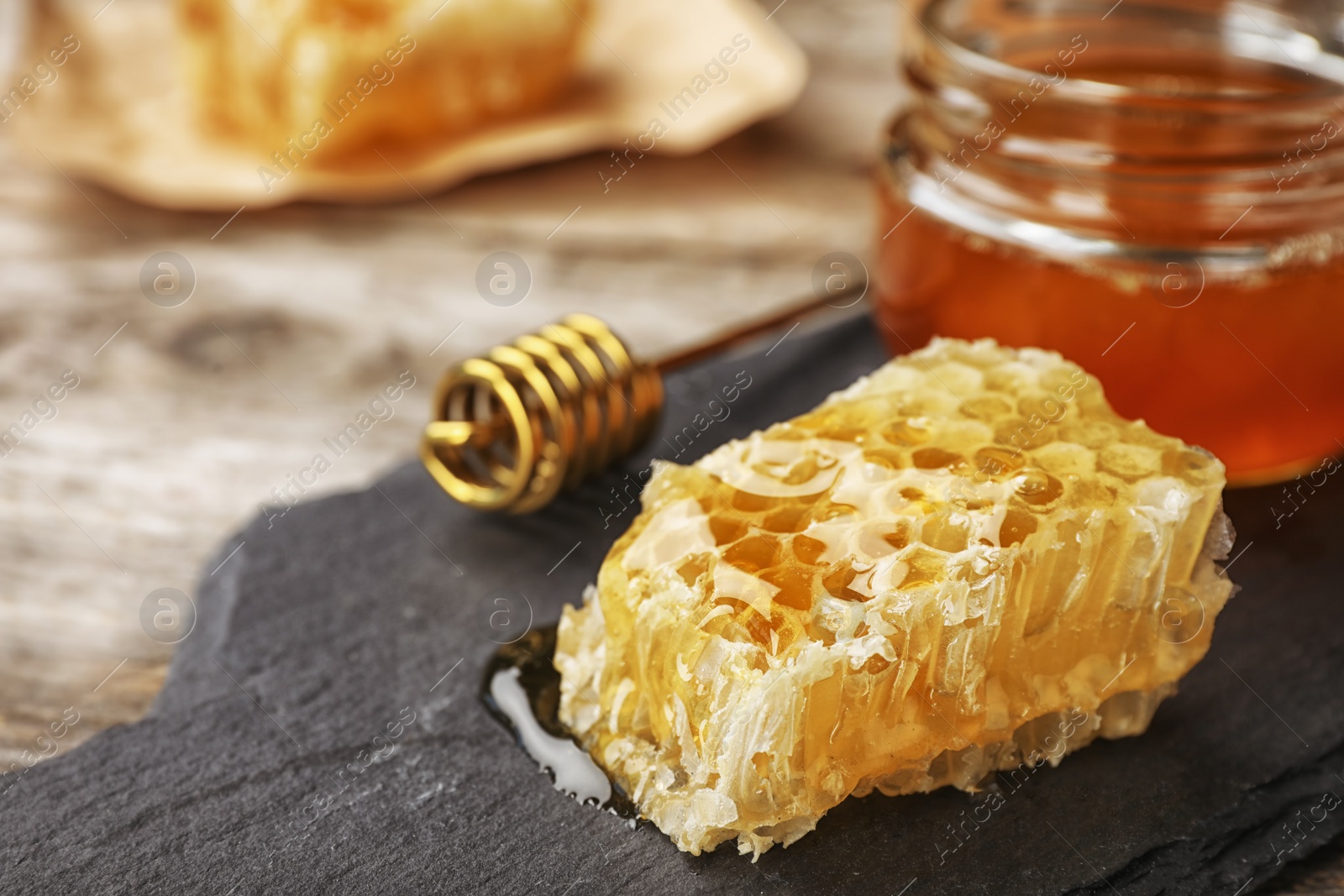 Photo of Honeycomb, dipper and jar on slate plate closeup