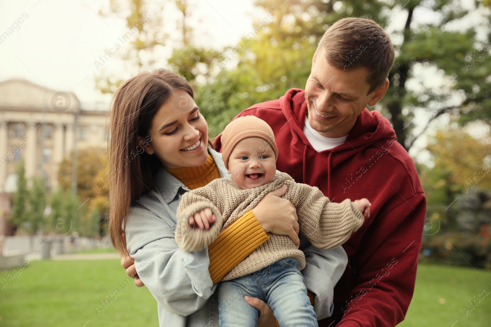 Photo of Happy parents with their adorable baby walking in park