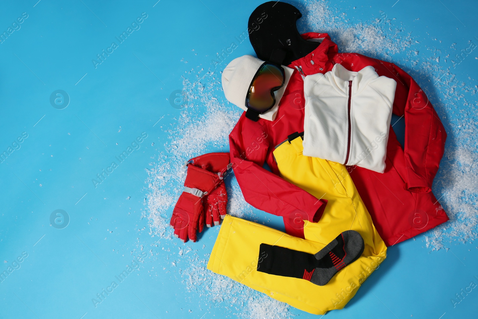 Photo of Stylish winter sport clothes on light blue background, flat lay. Space for text