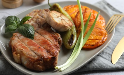 Photo of Delicious grilled meat and vegetables served on light grey table, closeup