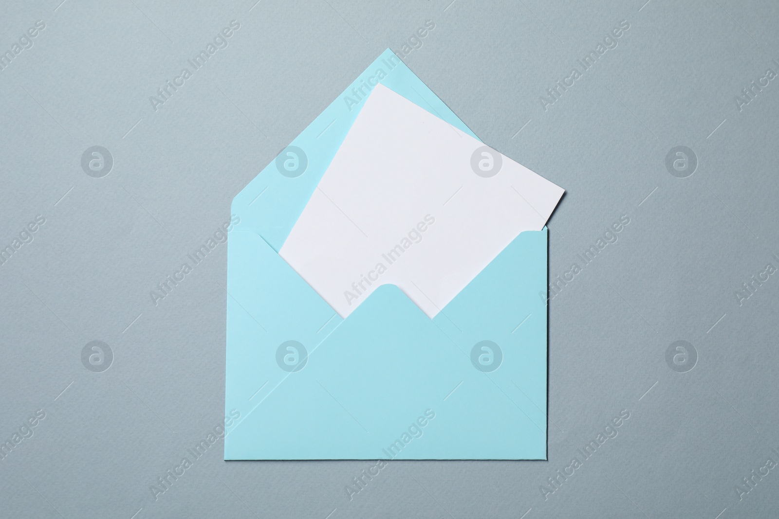 Photo of Letter envelope with card on grey background, top view