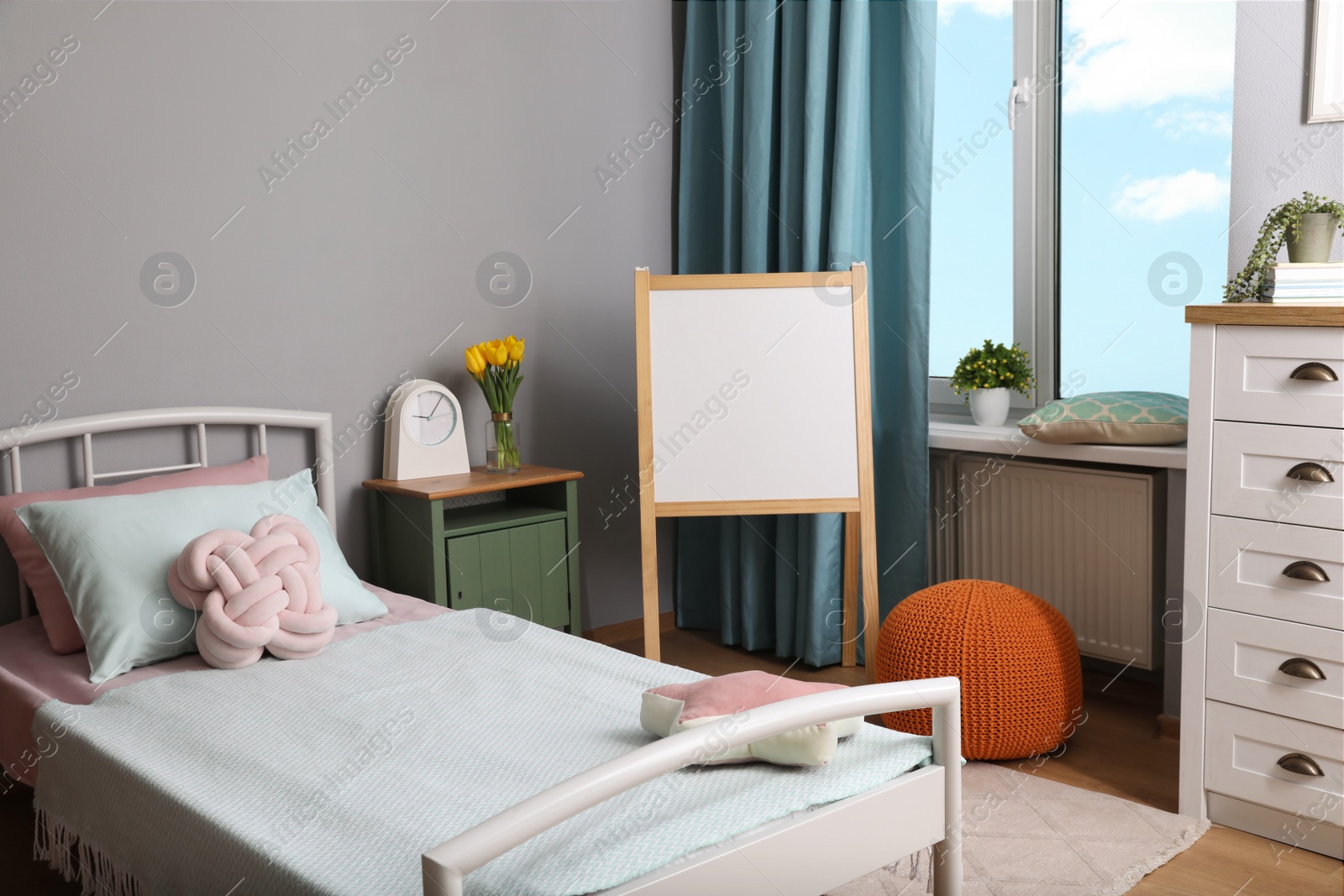 Photo of Stylish child room interior with comfortable bed and board