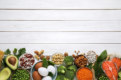 Products rich in protein on white wooden table, flat lay. Space for text