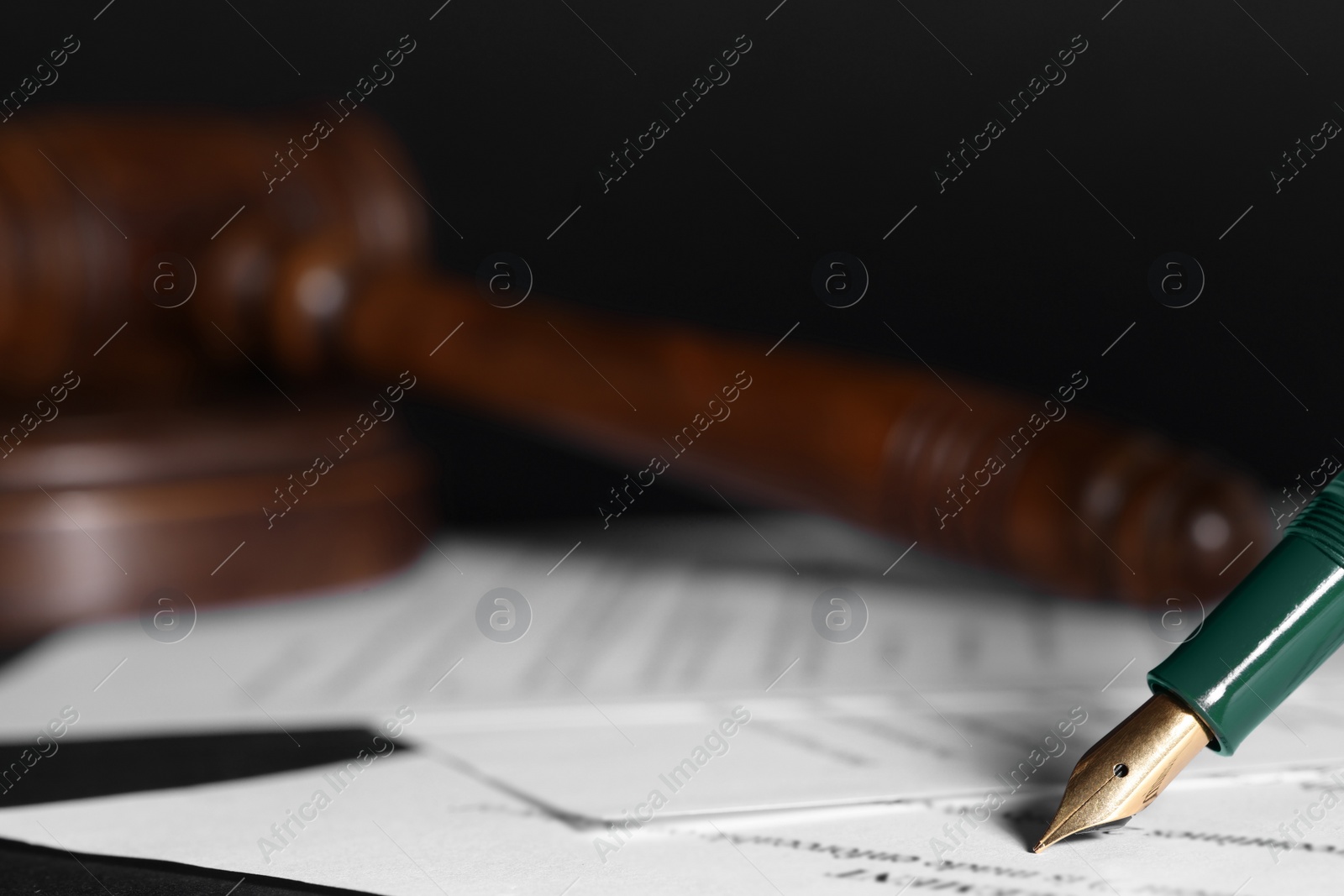 Photo of Writing on documents with fountain pen at table, closeup and space for text. Notary contract