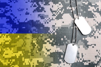 Image of Double exposure of Ukrainian flag and military ID tags on camouflage fabric