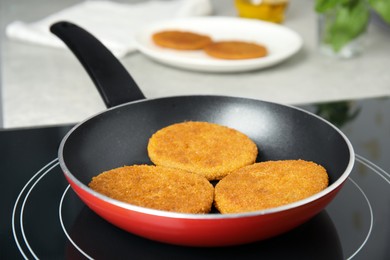 Photo of Cooking breaded cutlets in frying pan on stove