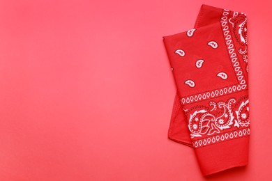 Photo of Folded bandana with paisley pattern on red background, top view. Space for text