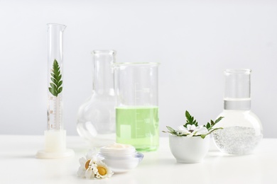 Photo of Skin care product, ingredients and laboratory glassware on table. Dermatology research