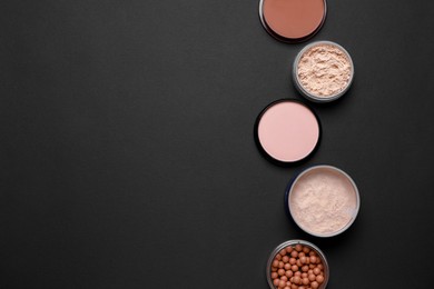 Different face powders on black background, flat lay. Space for text