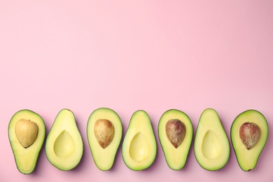 Photo of Cut fresh ripe avocados on pink background, flat lay with space for text