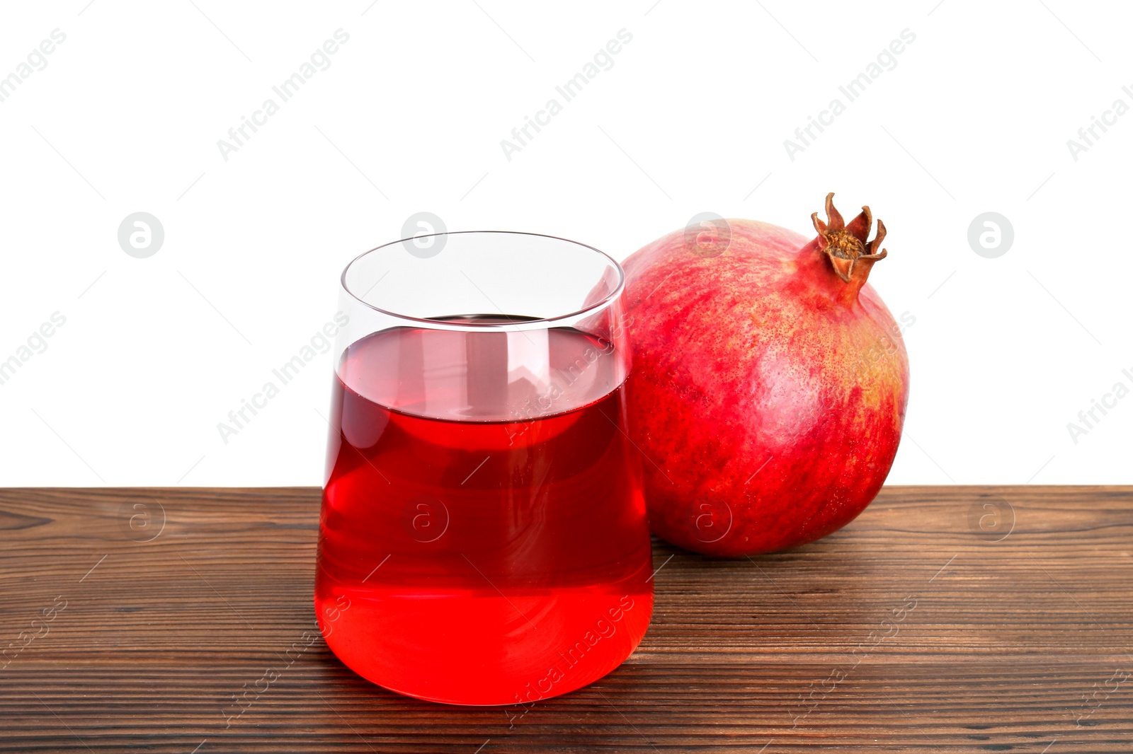 Refreshing pomegranate juice in glass and fruit on wooden table against white background Photo of Refreshing pomegranate juice in glass and fruit on wooden table against white background