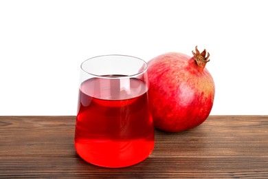 Photo of Refreshing pomegranate juice in glass and fruit on wooden table against white background