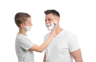 Son shaving his dad with razor isolated on white