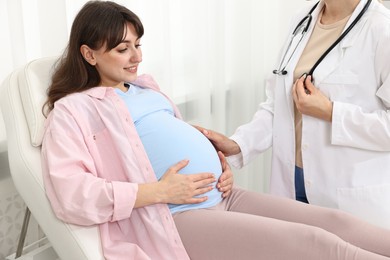 Happy pregnant woman having doctor appointment in hospital, closeup