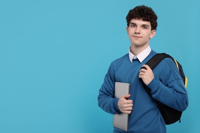 Portrait of student with backpack and laptop on light blue background. Space for text