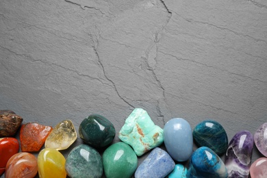 Photo of Flat lay composition with different gemstones on grey table, space for text