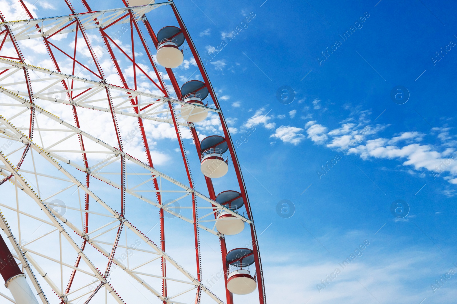 Photo of Beautiful large Ferris wheel against blue sky with clouds on sunny day