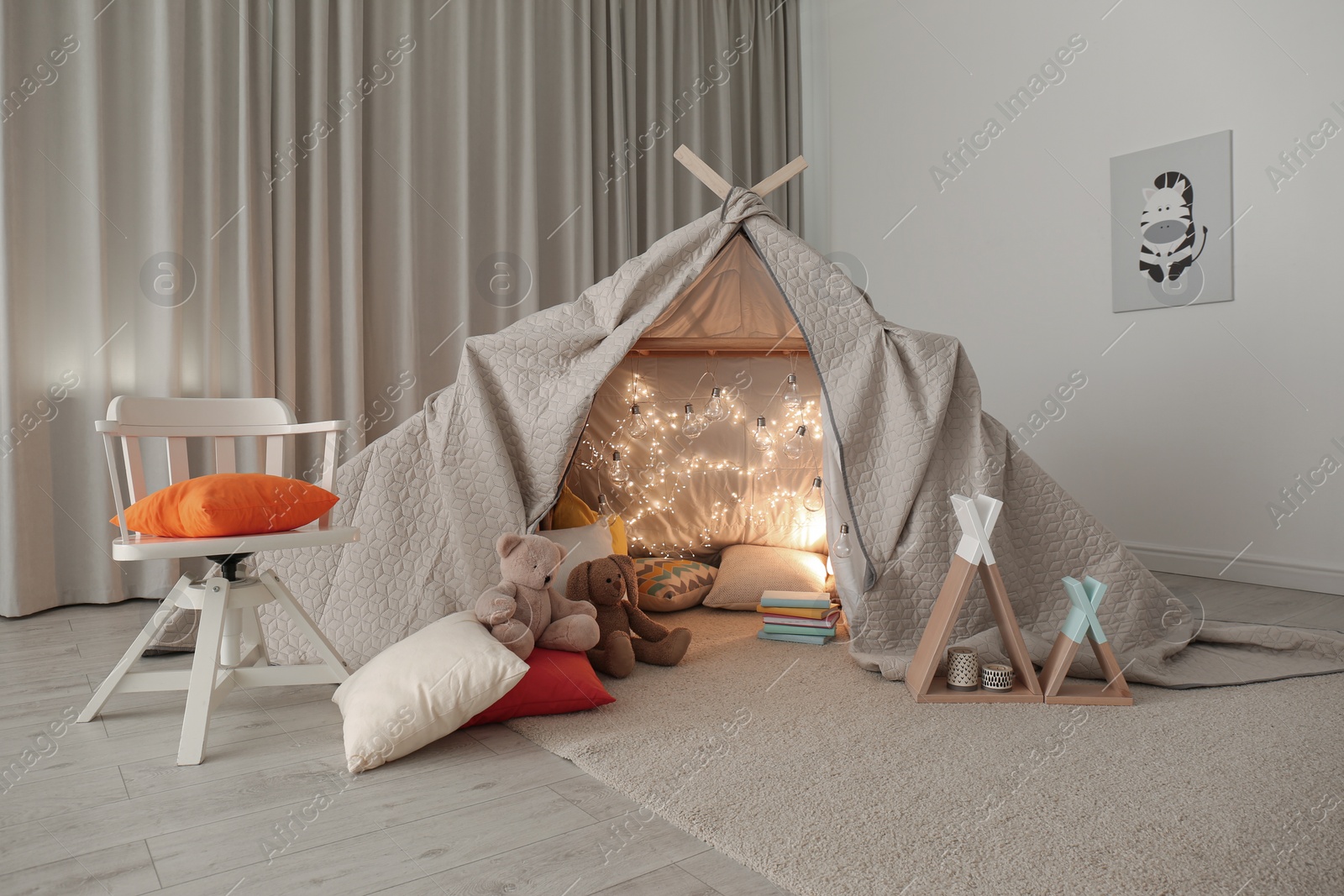 Photo of Play tent decorated with festive lights in modern child's room