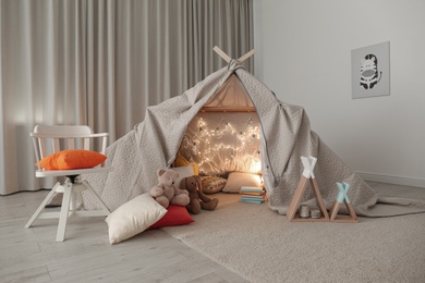 Play tent decorated with festive lights in modern child's room