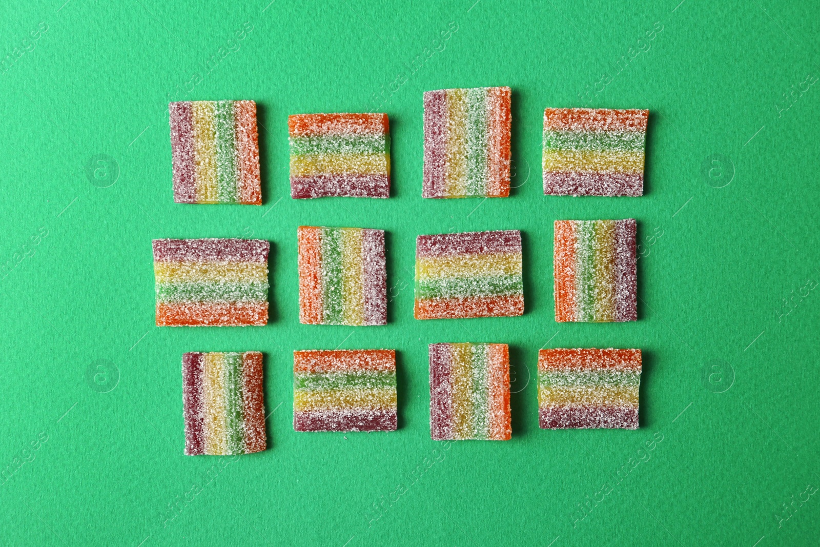 Photo of Flat lay composition with delicious jelly candies on color background