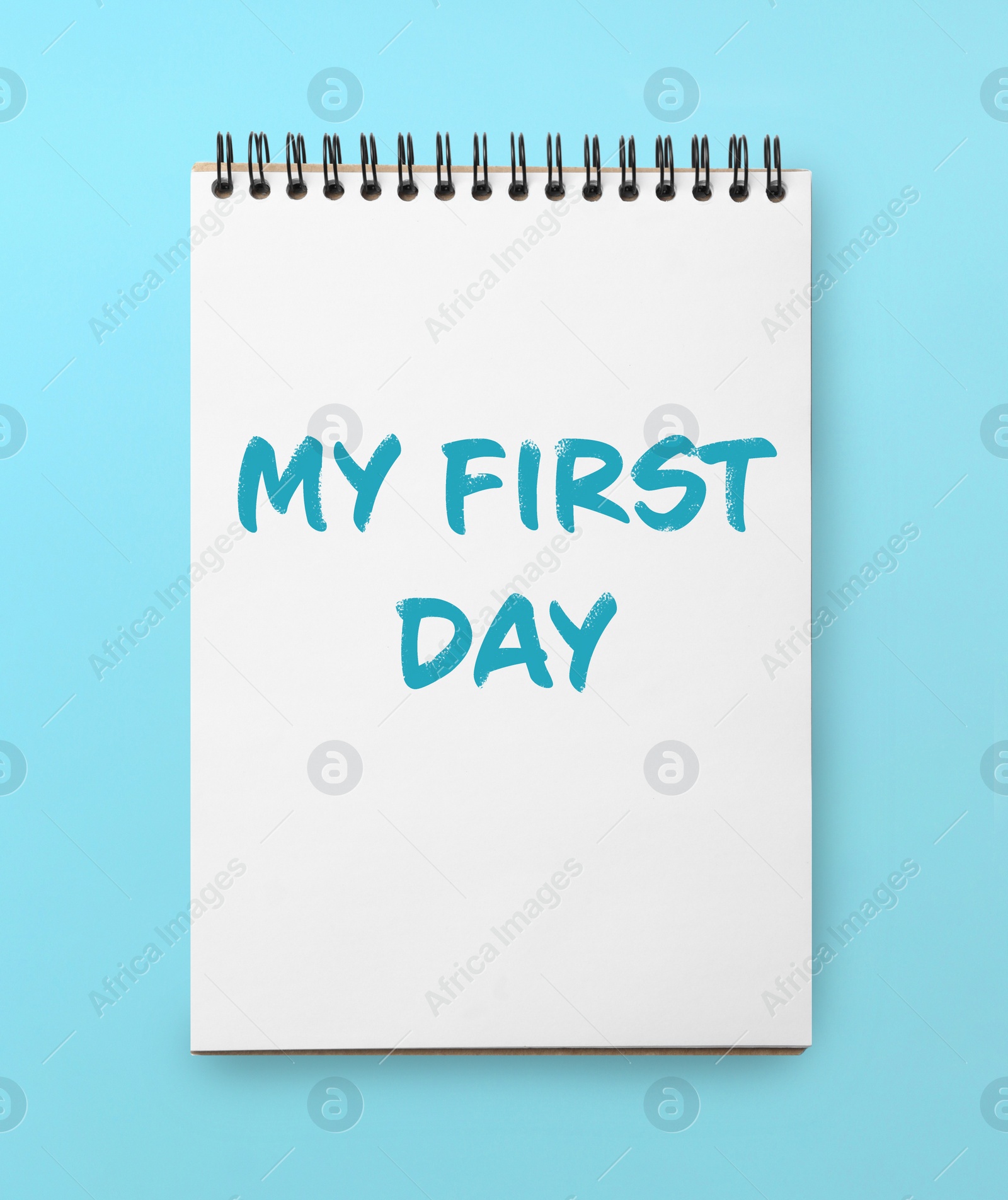 Image of New life beginning. Notebook with text My First Day on light blue background, top view